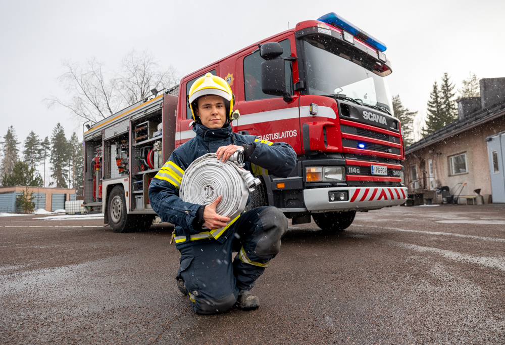 Palokunnan päällikkö Jesse Okka poseeraa paloauton edessä