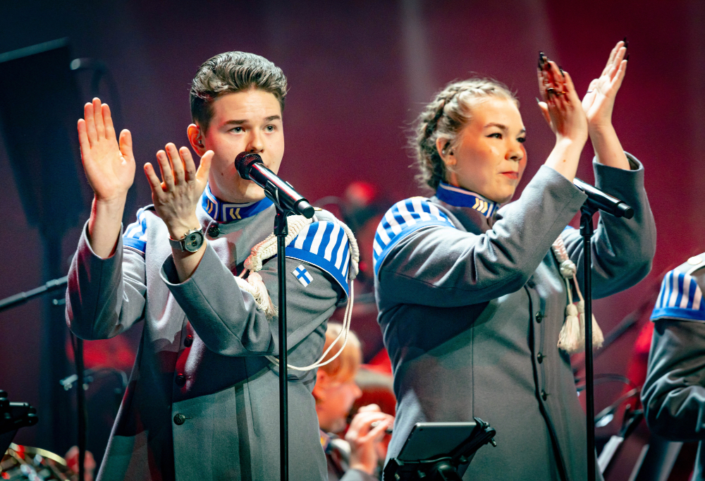 Kaksi solistia taputtaa tahtia ja laulaa.