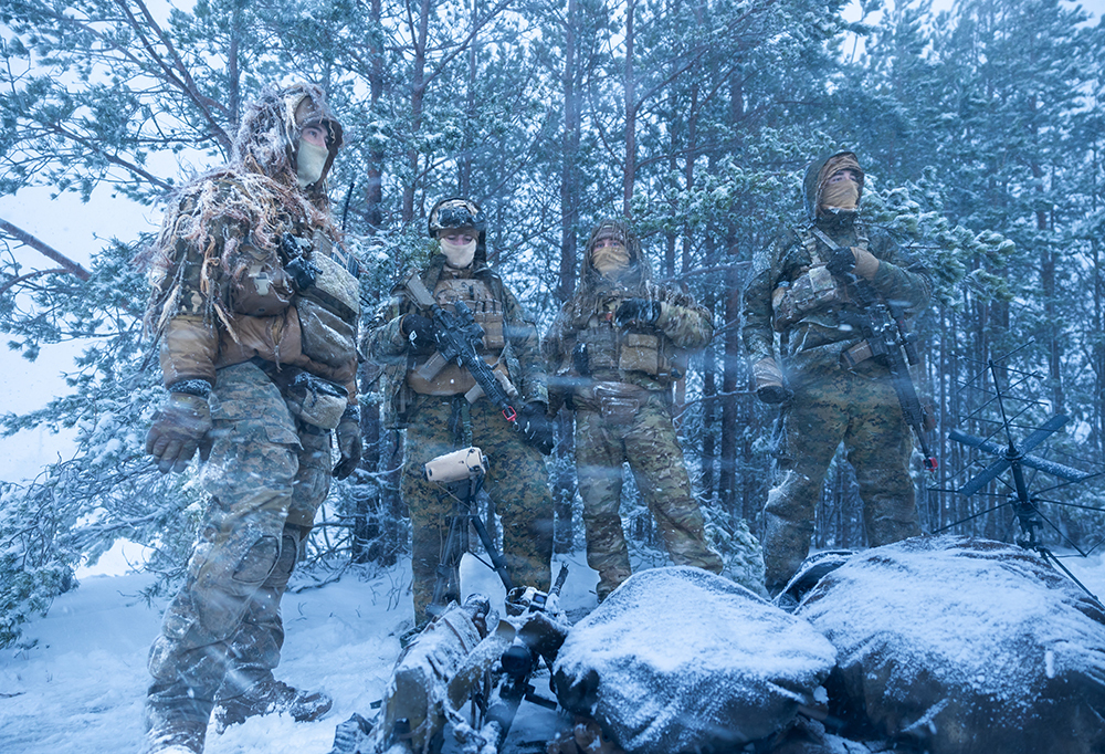 Neljä taistelijaa lumisessa metsässä.