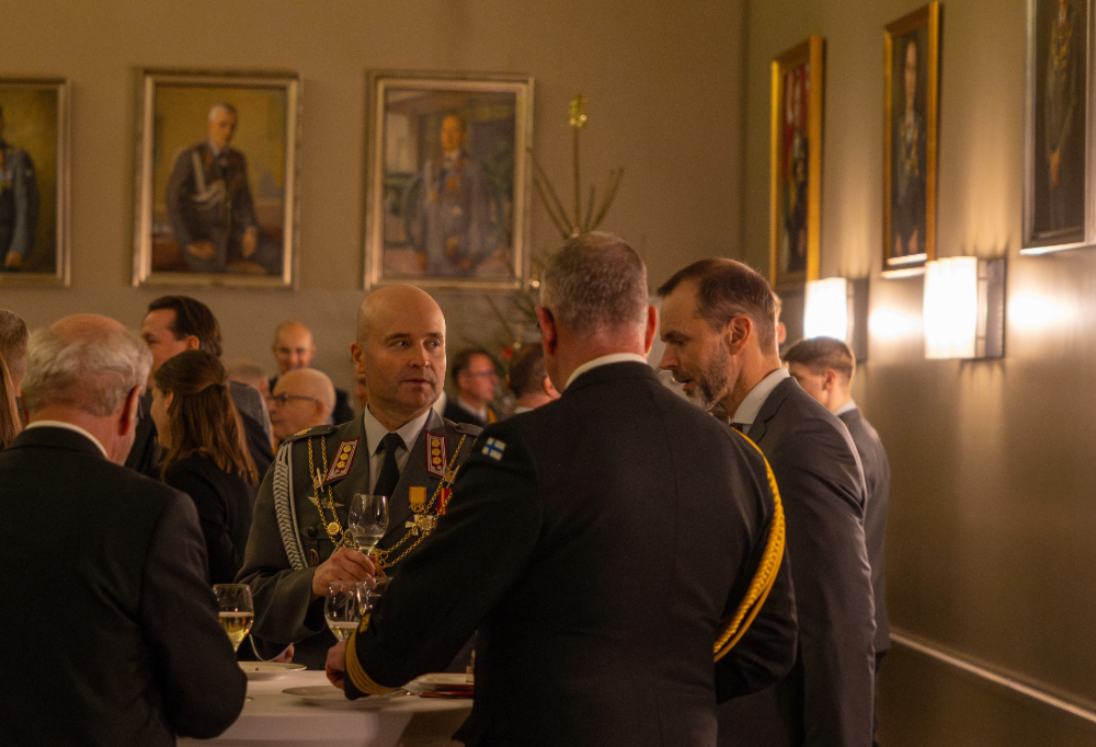 Eversti Jaro Kesänen keskustelee juhlasalissa.