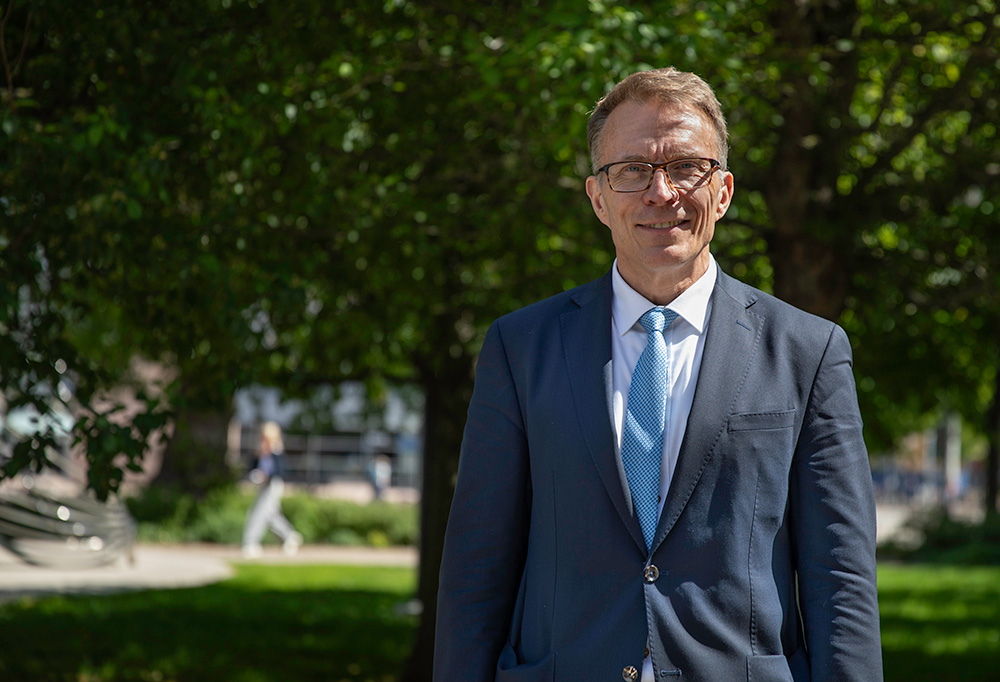 Puolustuksen parlamentaarisen työryhmän puheenjohtaja Jukko Kopra katsoo kameraan puistossa.