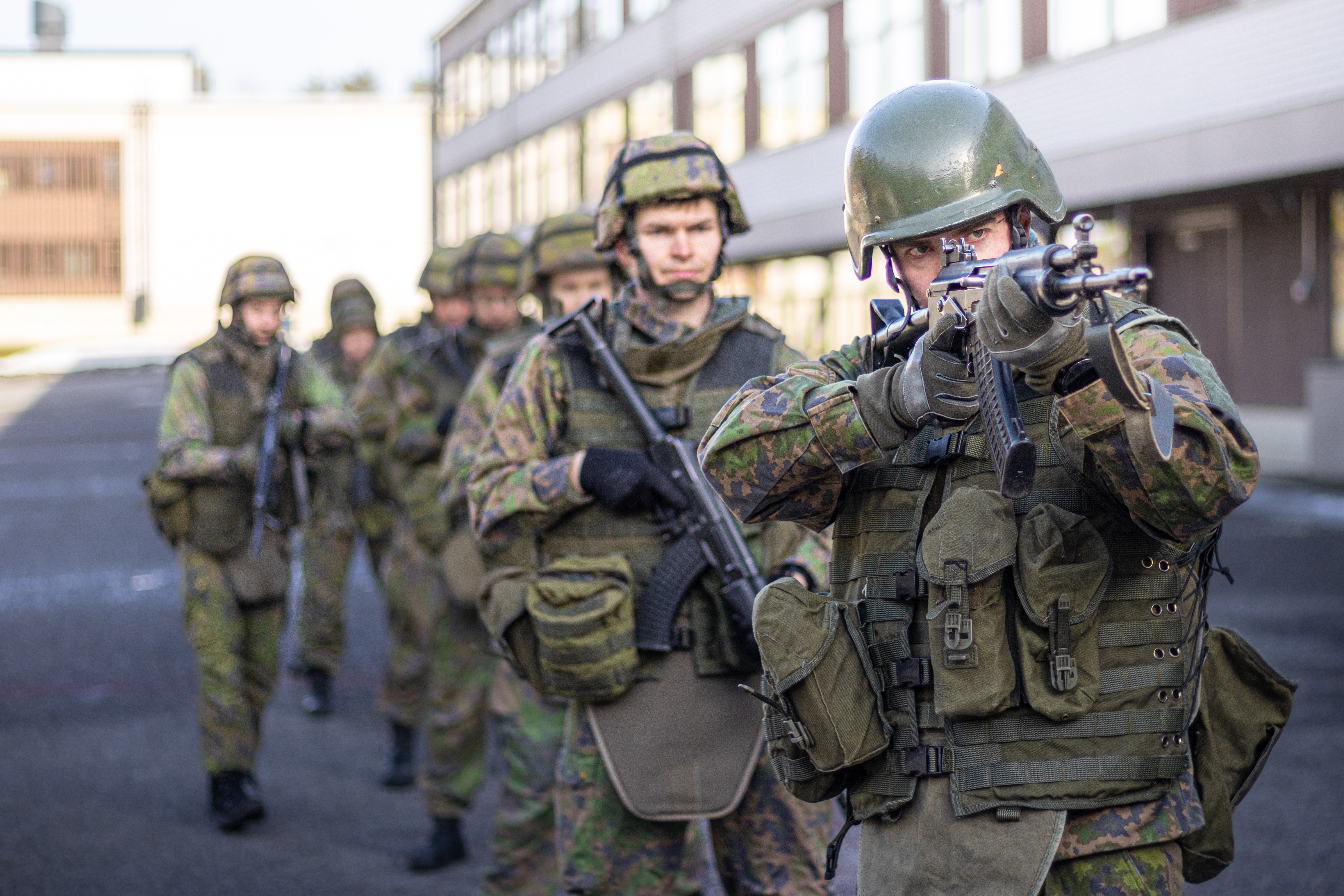 Kuvassa on jonossa sotilaita, joista ensimmäinen tähtää aseellaan eteenpäin.