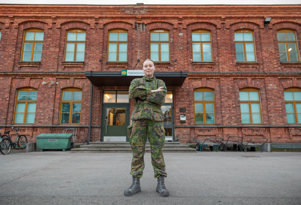 Kuvassa kaartinjääkäri Salovaara katsoo kameraan kädet puuskassa maastopuvussa komppanian edessä.
