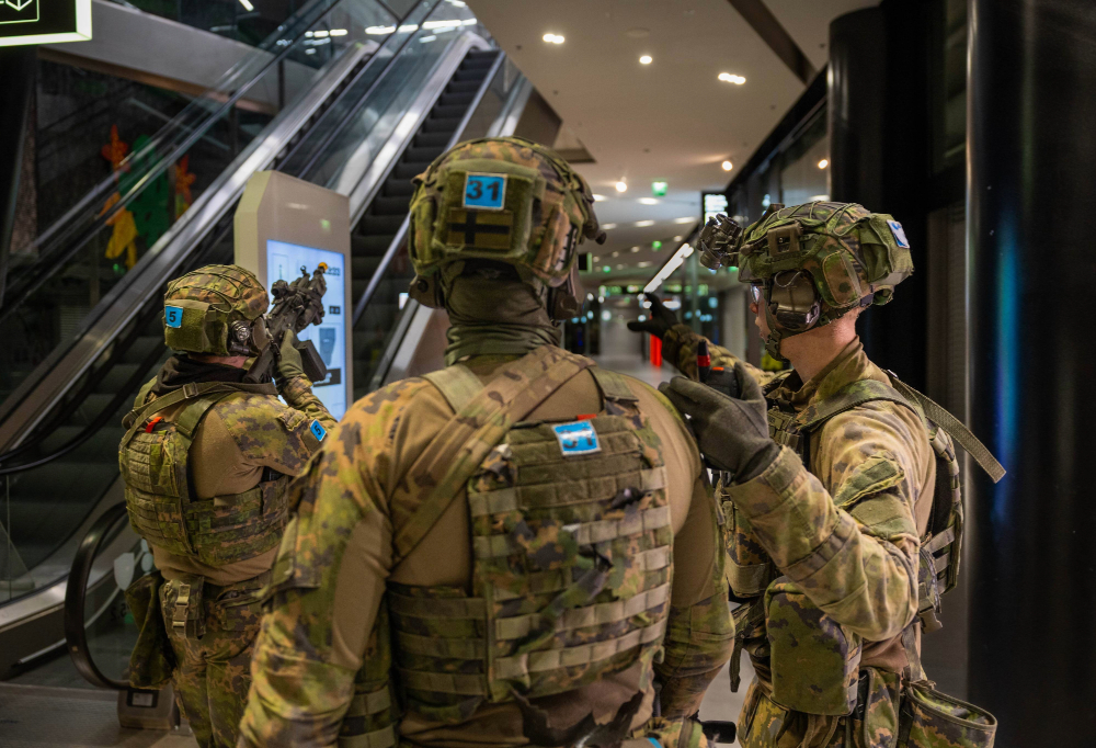 Kuvassa valmiusyksikköön kuuluvat varusmiehet vartioivat kauppakeskuksen liukuportaikkoa.