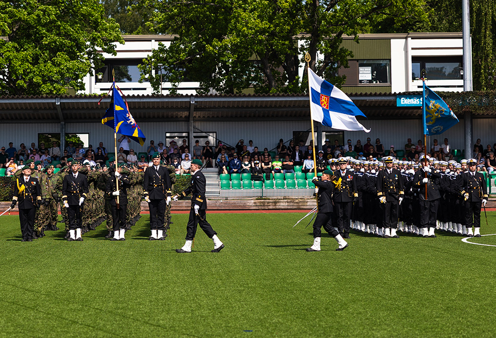 Joukkueet kantavat lippuja.
