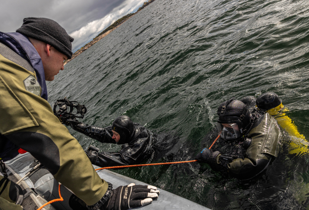 Sukeltajakoululaisia nousemassa ylös vedestä veneeseen.