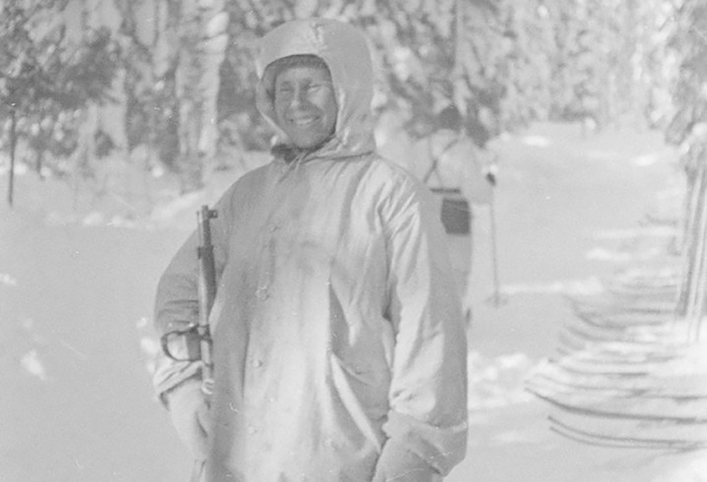 Simo Häyhä pitää asetta kädessään.