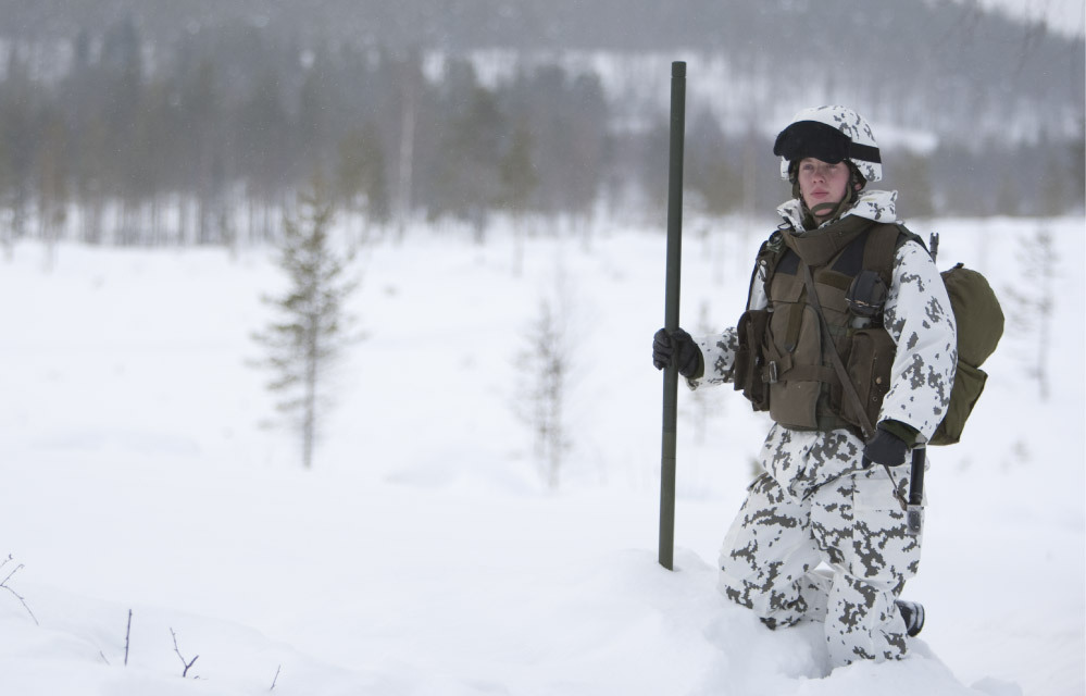 Kuvassa M05-sirpalesuojaliivi taistelijan päällä siihen kiinnitettyjen varustetaskujen kanssa.