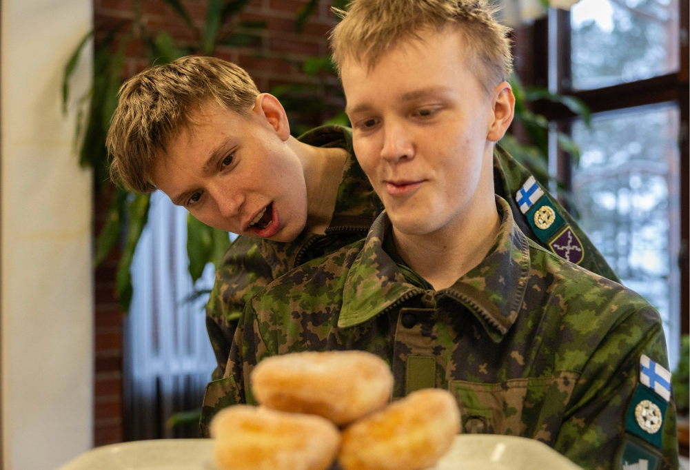 Kuvassa varusmiehet katsovat sotilaskodin munkkeja nälkäisinä.