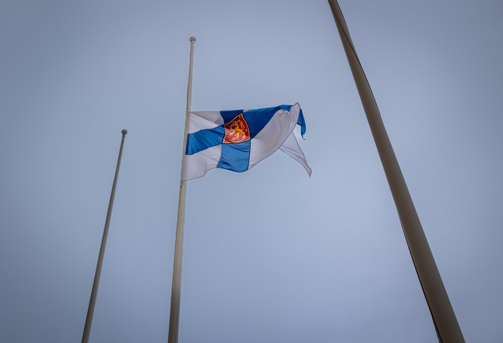 Kuvassa Suomen lippu ja kolme lipputankoa.