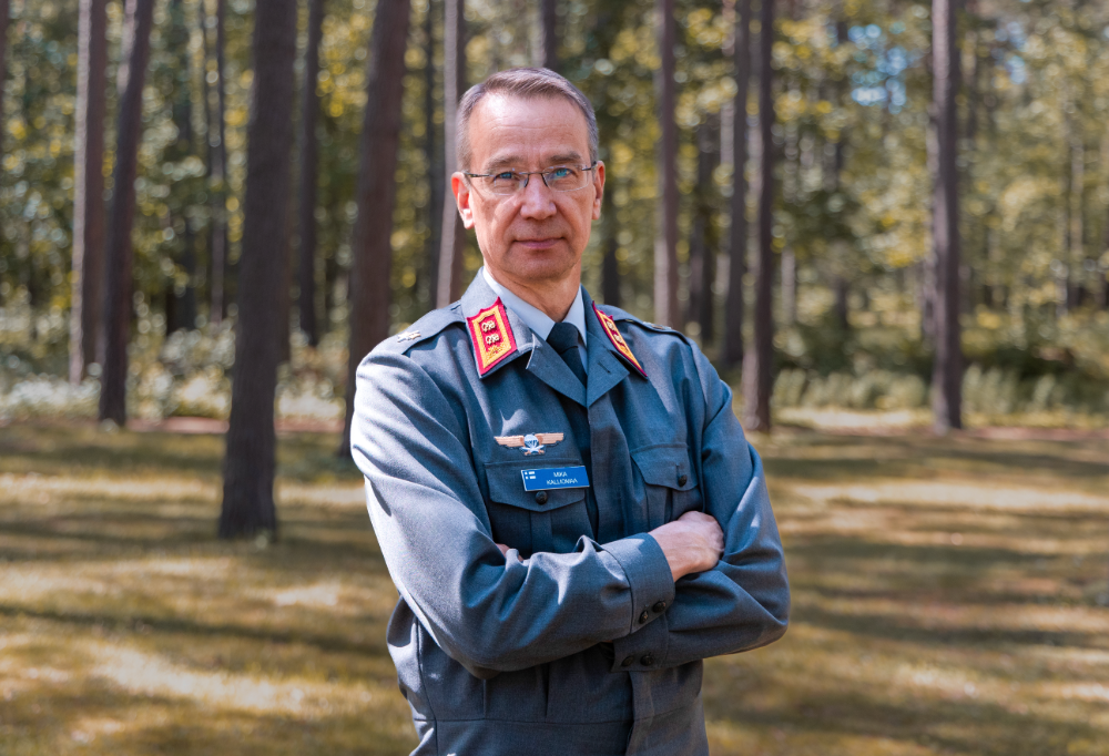 Kenraalimajuri Mika Kalliomaa seisoo luonnossa kädet puuskassa.
