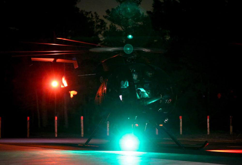 Helikopteri pimeällä lentokentällä.