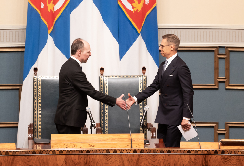 Presidentti Alexander Stubb ja puhemies Jussi Halla-aho kättelevät puhemiehen korokkeella.