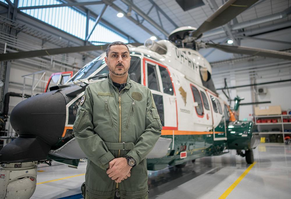 Arman Alizad Rajavartiolaitoksen helikopterin edessä hallissa.