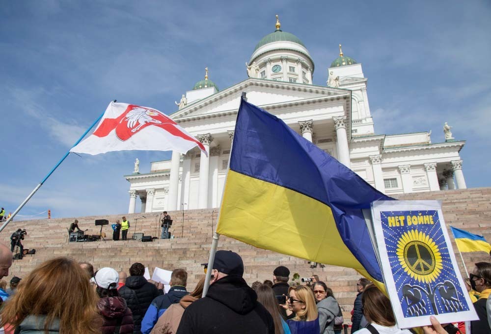 Kuvassa Ukrainan lippu ja taustalla Tuomionaukion kirkko.