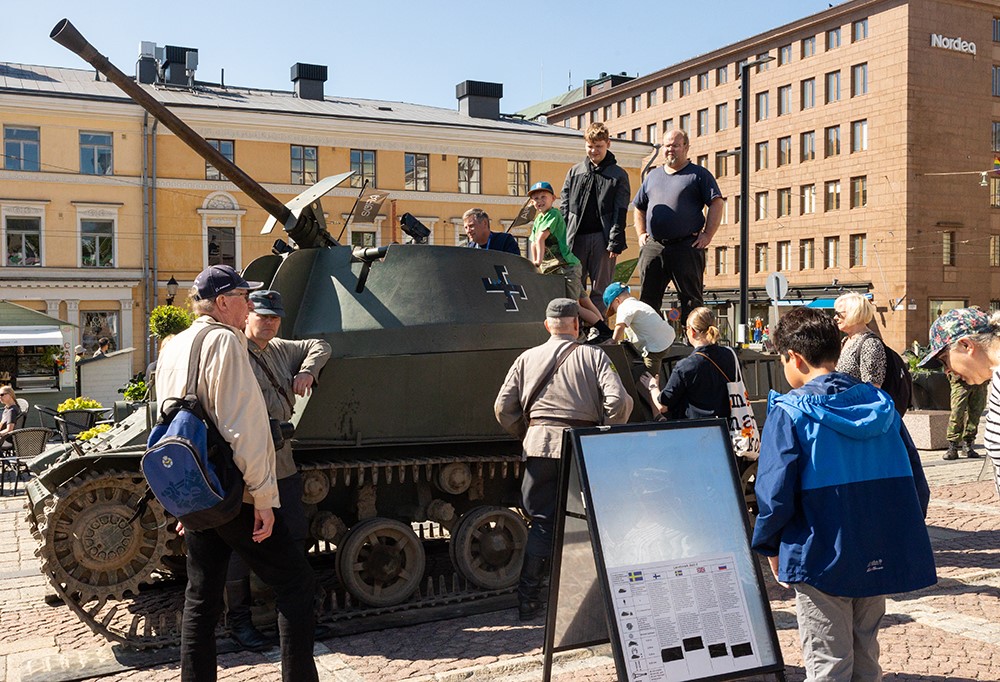 Varusmiehet esittelevät panssarivaunua kansalaisille.