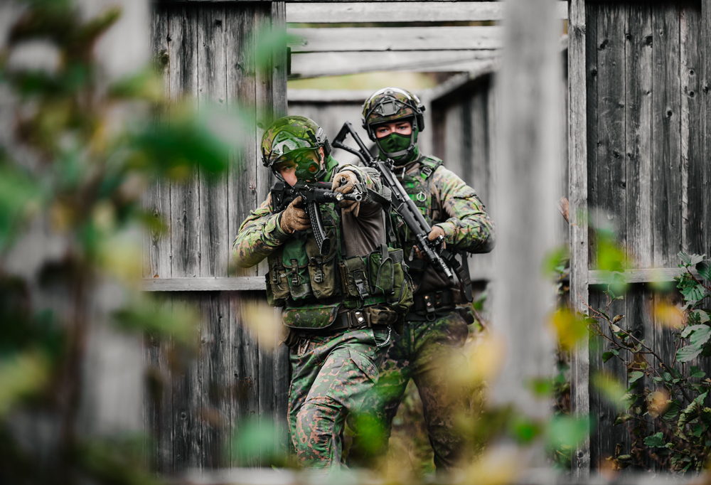 Kuvassa kaksi taistelijaa hartjoittelevat taistelua rakennetulla alueella.