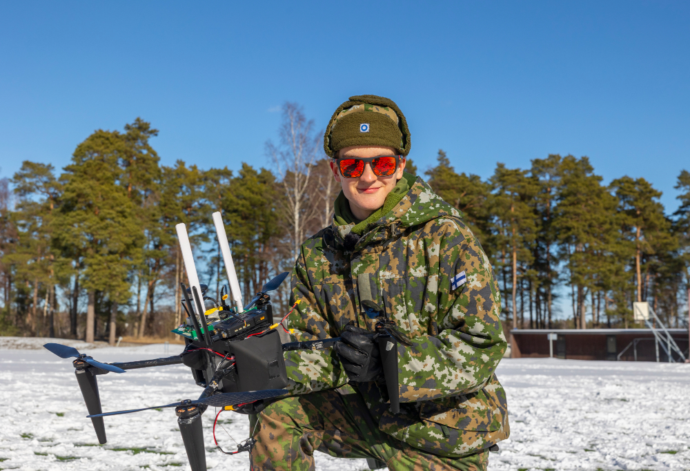 Kuvassa kaartinjääkäri Markus Aarrejoki pitää käsissään droonia.