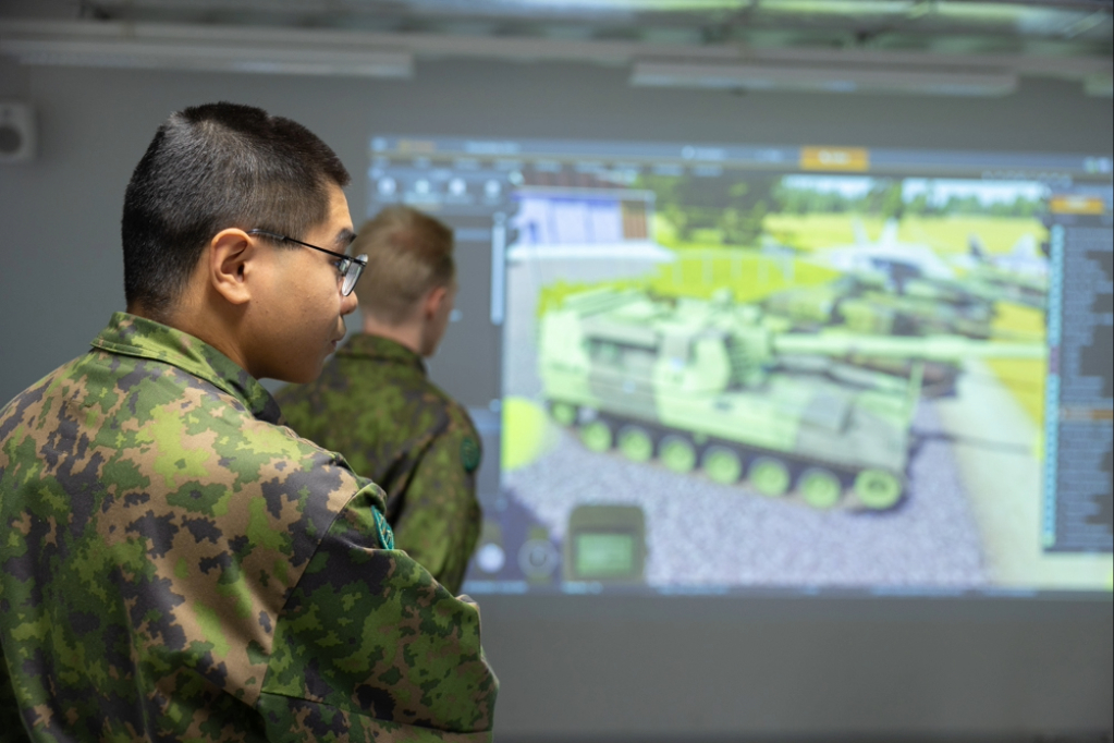 Kaksi varusmiestä tutustuvat simulaattoriin.