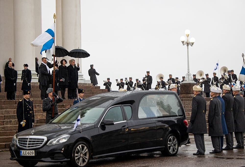 Kuvassa tasavallan presidentti Sauli Niinistö ja puoliso Jenni Haukio seurasivat, kun kenraalit lastaavat arkkua autoon.