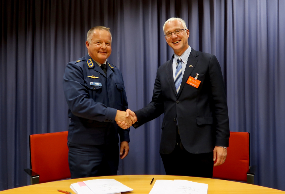 Juha-Matti Ylitalo kättelee Seppo Aaltosta pöydän ääressä.