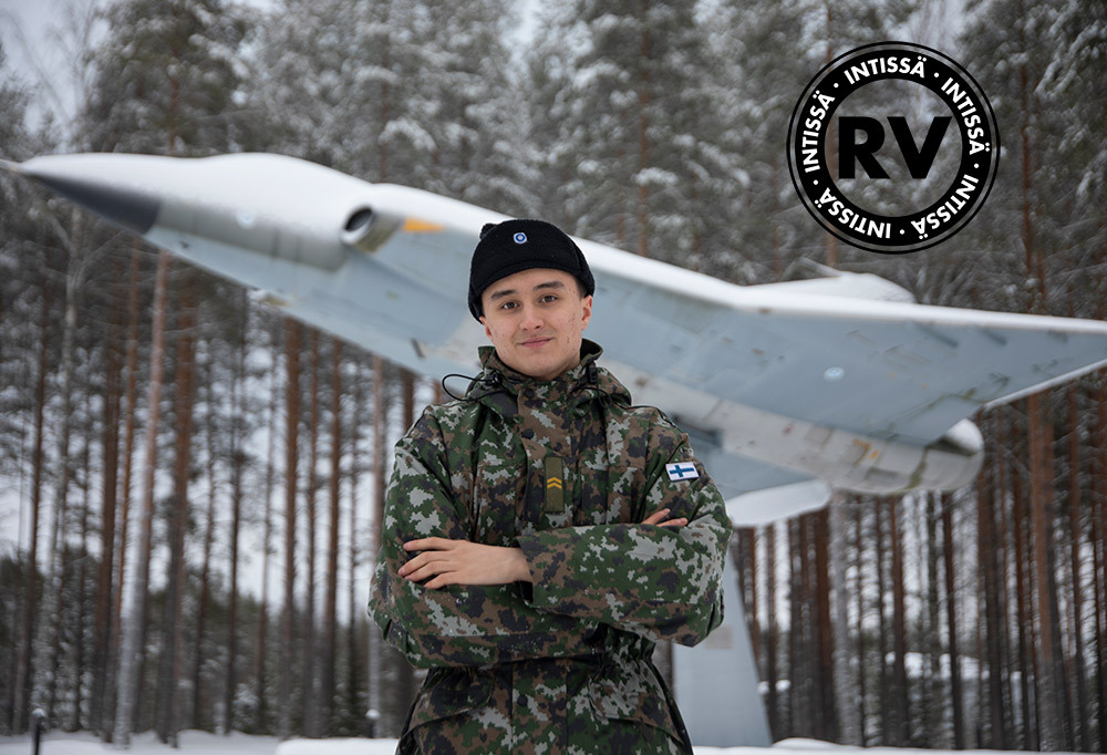 Alikersantti Kangasniemi poseeraa hävittäjämuistomerkin edessä.