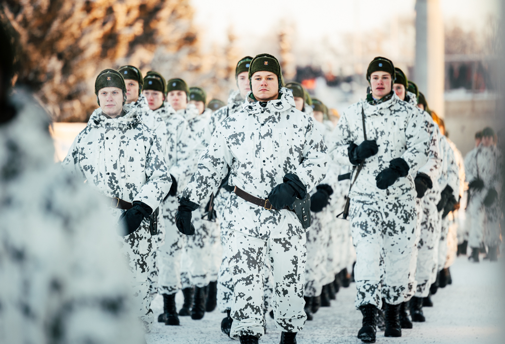 Kuvassa lumipuvuissa marssivia joukkoja