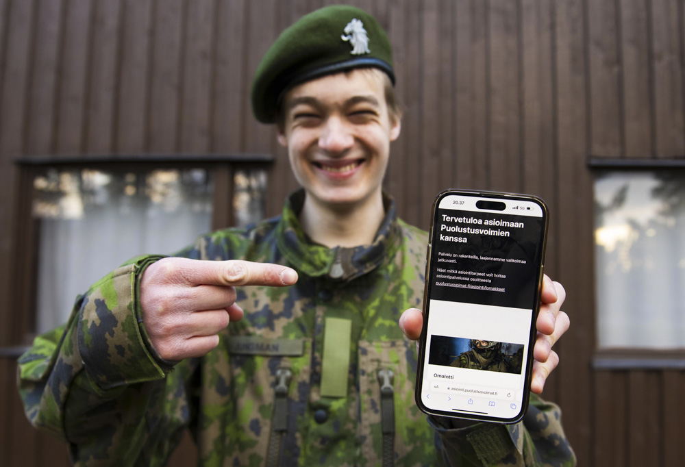Sotilas esittelee älypuhelintaan.