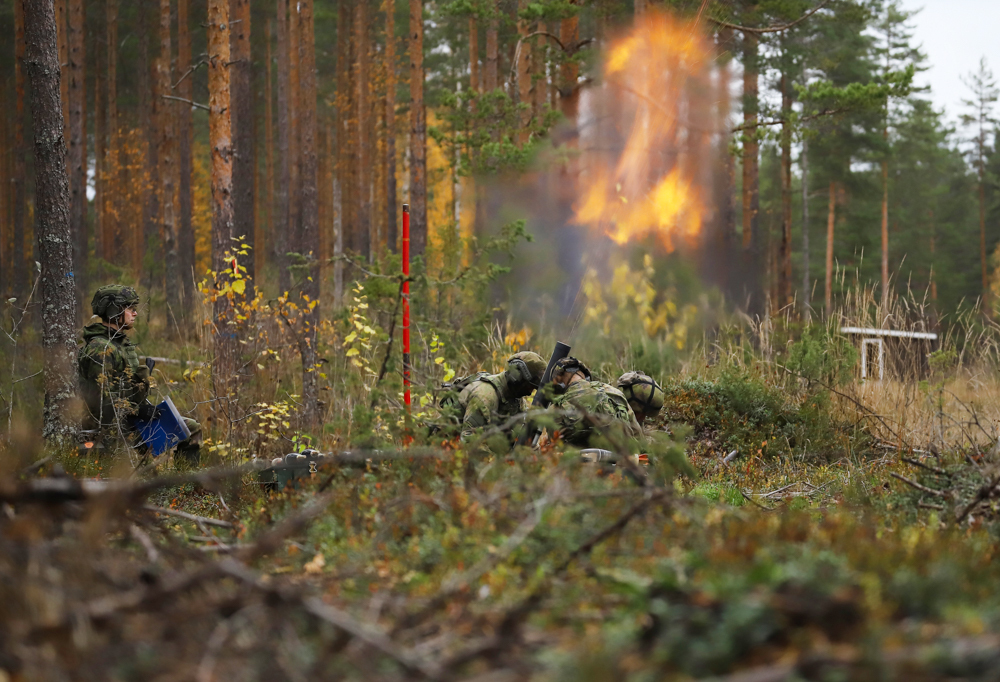 Kranaatinheittimen laukaus metsämaastossa.