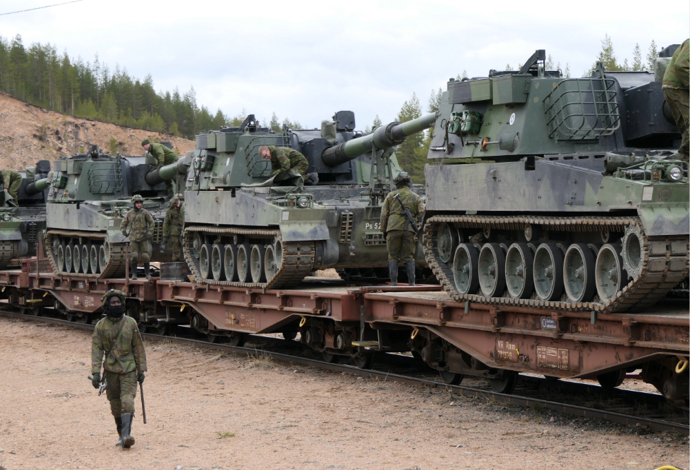 Kuvassa panssaroituja ajoneuvoja jonossa.