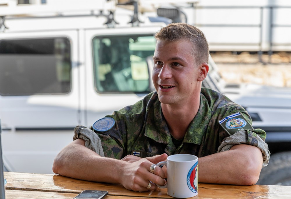 Suomalainen rauhanturvaaja istumassa kahvikupposen ääressä.