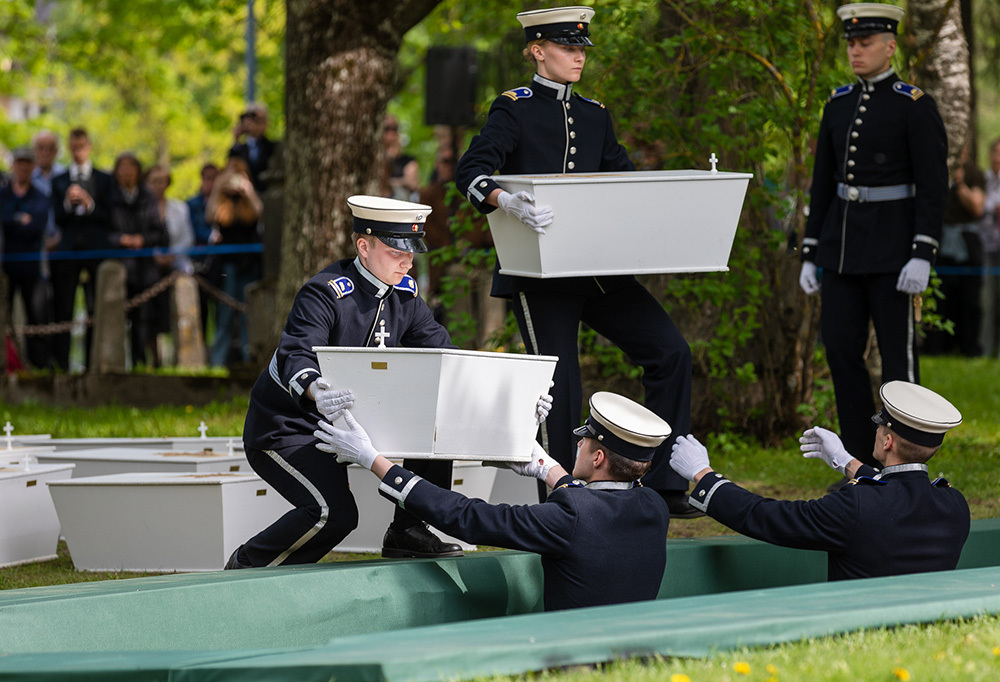 Kadetit laskevat sankarivainajan arkkua hautaan