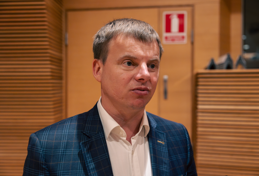 Parlamentaarikkoavustaja Yuriy Karchenko katsoo etuviistoon. Taustalla puinen seinä.