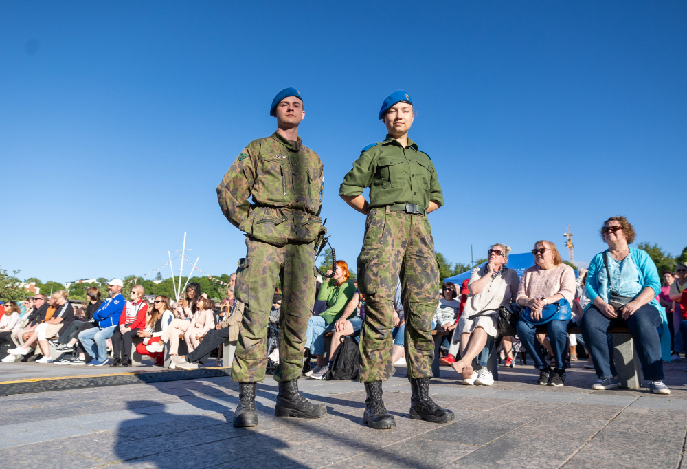 Kuvassa seisovat kaksi varusmiestä konserttiyleisön edessä.