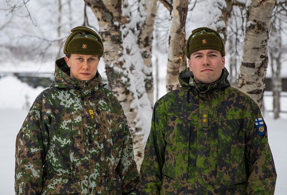 Kaksi kantahenkilökunnan jäsentä, nainen ja mies, talvivarusteissa ulkona.