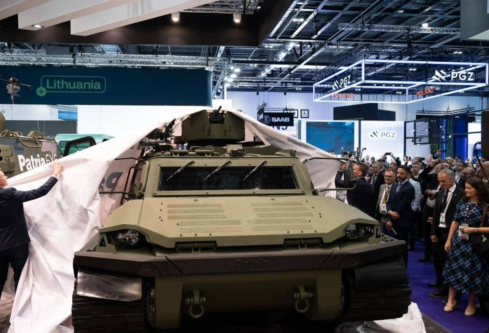 Kuvassa Patrian tela-ajoneuvon päältä nostetaan peitettä julkistuksen yhteydessä.