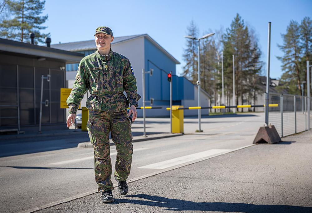 Kuvassa kersantti Linnea Landvik kävelee tiesulun edessä maastopuvussa.