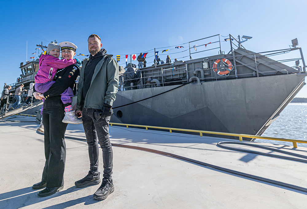 Alikersantti Wilma Tuominen, hänen siskonsa Hilla Tuominen ja hänen isänsä Valtteri Tuominen seisovat aluksen edessä.