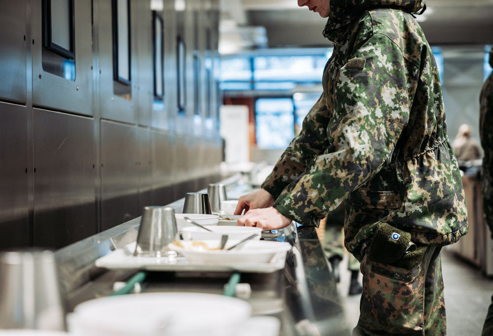 Varusmies ottaa ruokaa linjastolta.