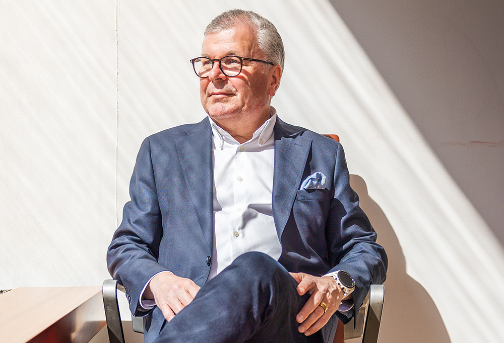 Kuvassa investointipankkiiri Ari Lahti istuu tuolissa puku päällä.