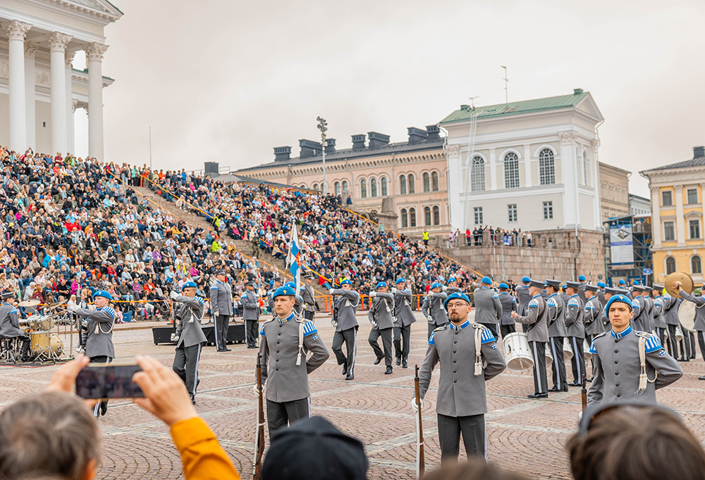 Puolustusvoimien soittokunta esiintymässä siniharmaissa puvuissa Tuomiokirkon edessä.