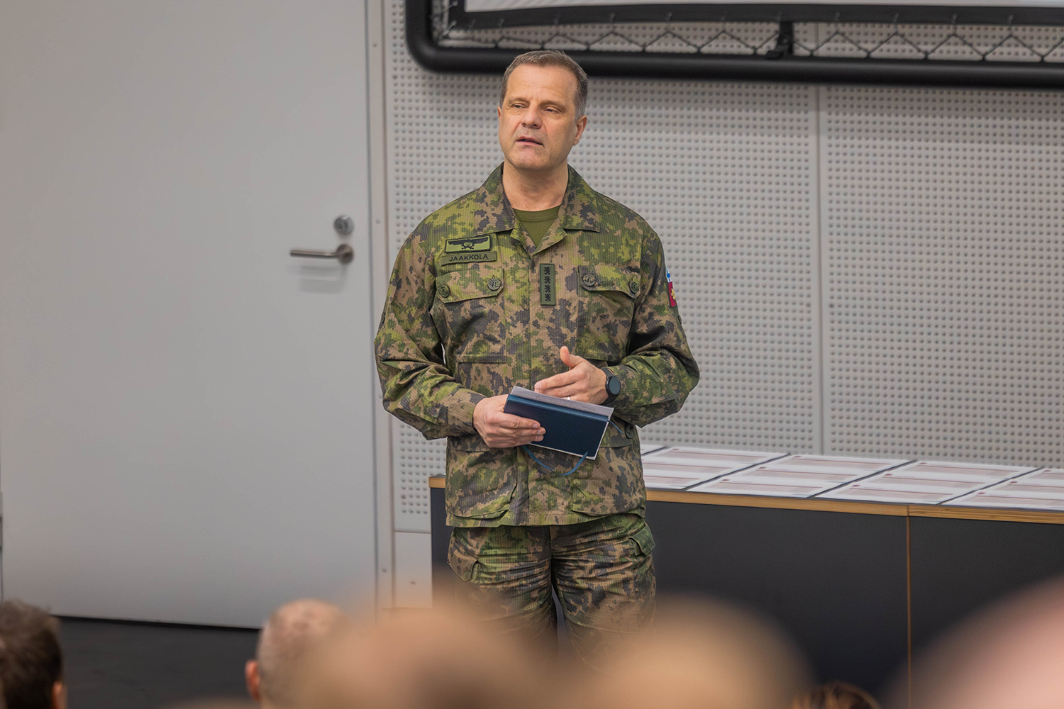 Kuvassa Puolustusvoimain komentaja, kenraali Janne Jaakkola luennoi yleisölle kirja kädessään.