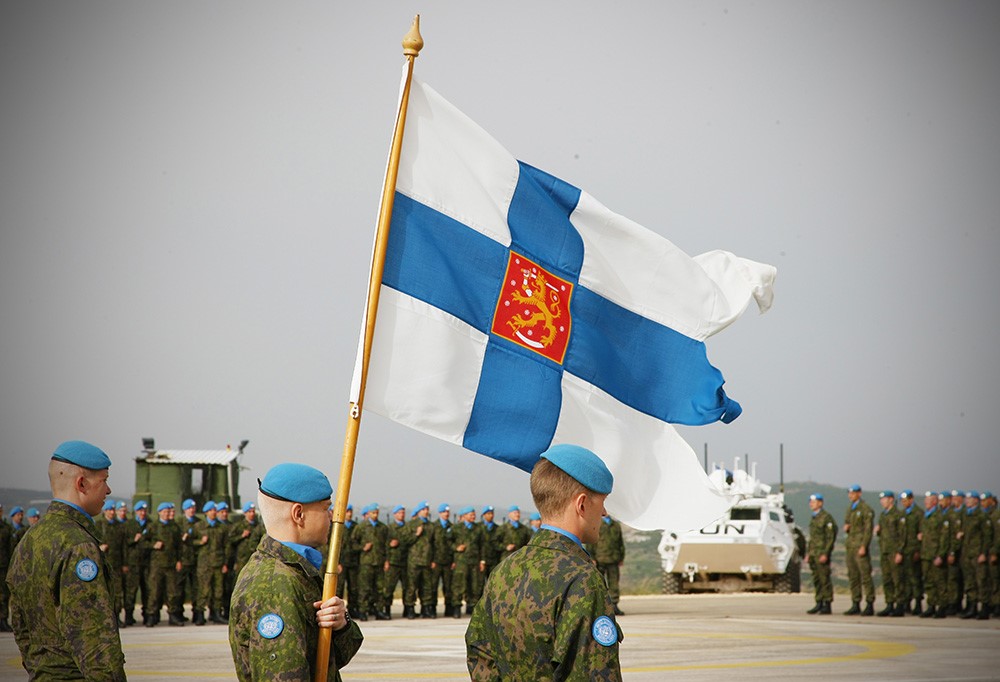 Suomalaisia rauhanturvaajia ja Suomen lippu.