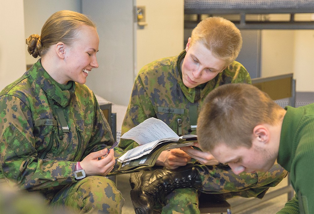 Kuvassa nais- ja miesvarusmiehiä tuvassa.