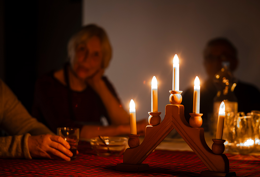 Joulukynttelikkö pöydällä tunnelmallisessa valaistuksessa