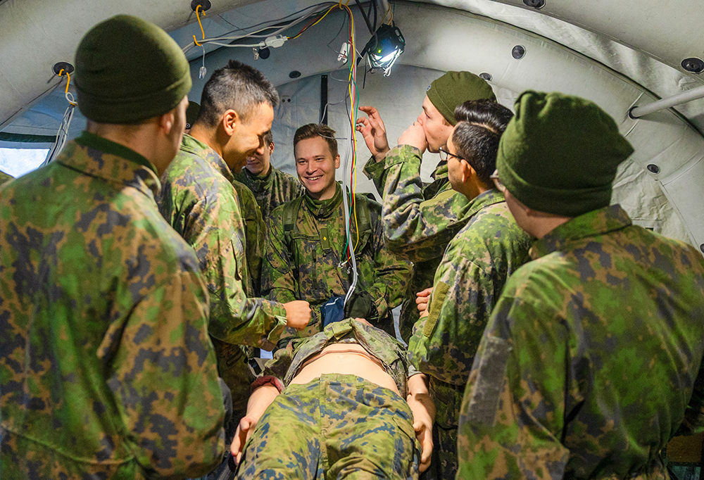 Upseerioppilaat potilasta esittävän nuken ympärillä.