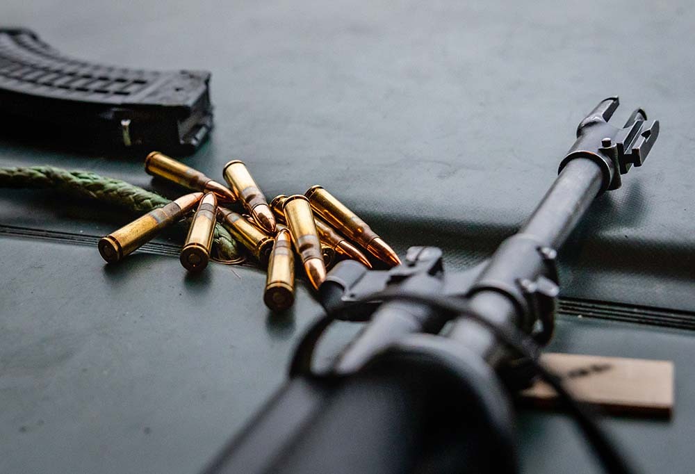 Kuvassa rynnäkkökiväärin piippu ja patruunoita.