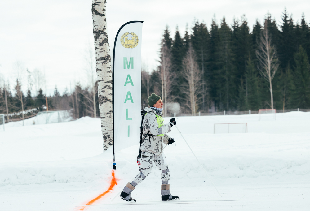 Kuvassa hiihtäjä lumipuvussa