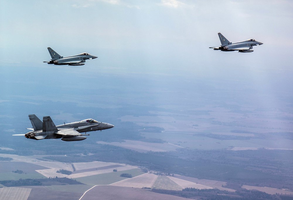 Kolme hävittäjää kirkkaalla taivaalla.