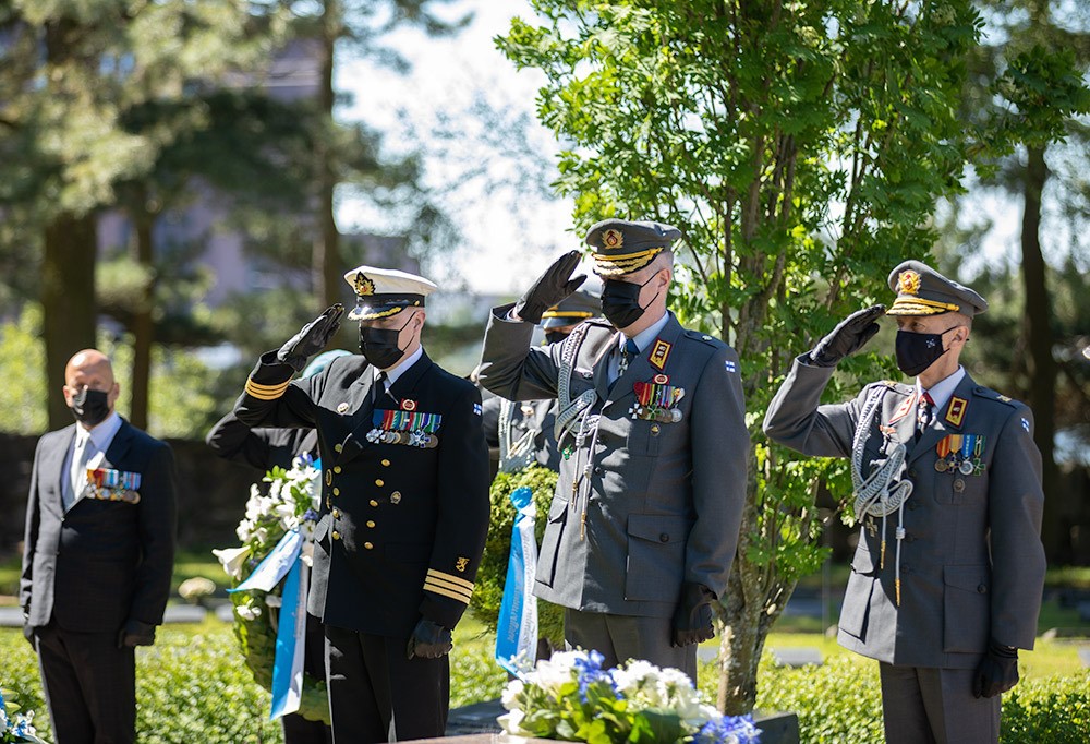 Kolme sotilasta tekemässä kunniaa juhlavarustuksessa.